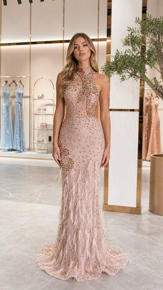 Front view of model wearing blush pink halter neck beaded gown with feather skirt
