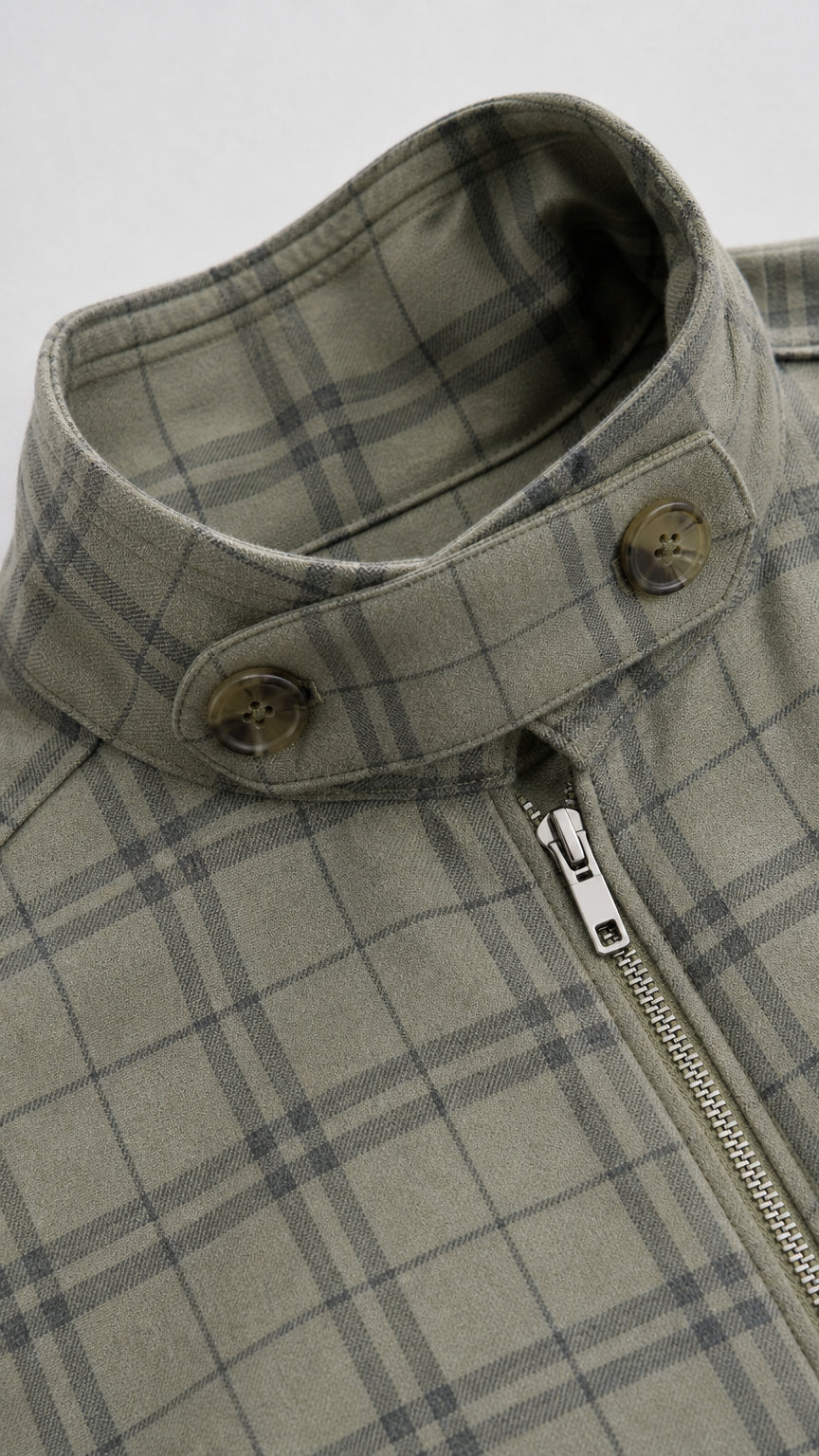 Close-up of stand collar with button tab and zipper on sage green plaid jacket