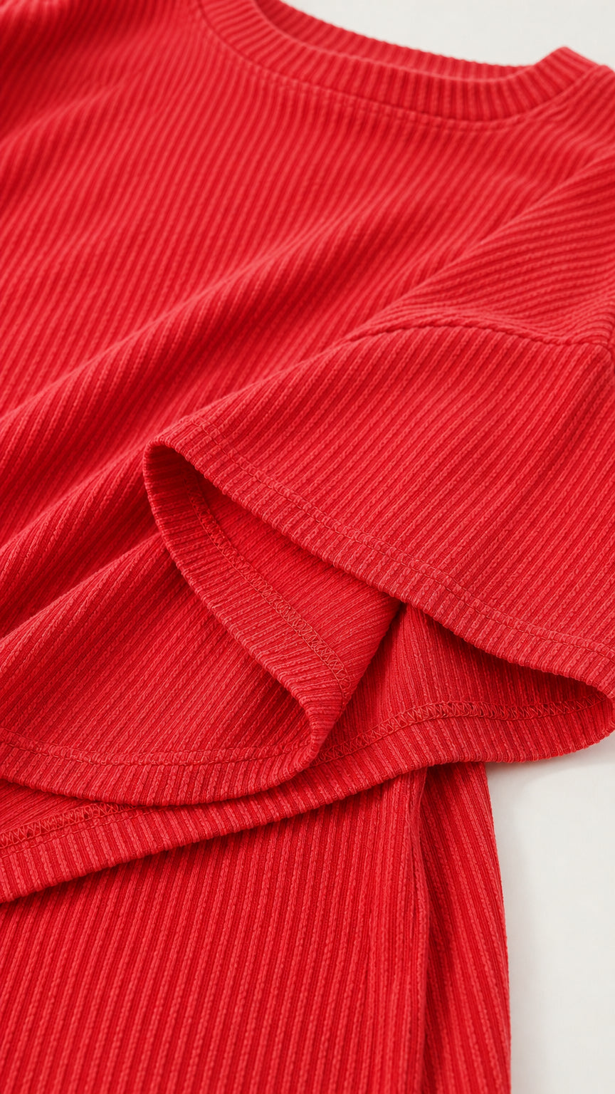 Close-up detail of textured red ribbed knit fabric and crew neckline