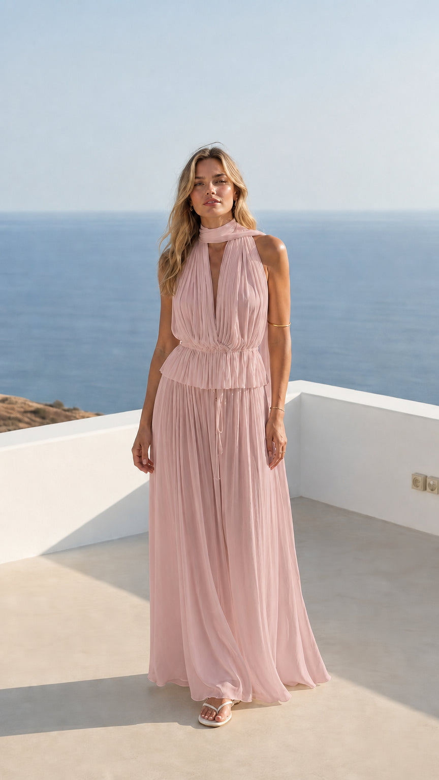 Woman wearing soft pink pleated halter maxi dress outdoors
